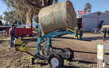 Electric loader lifting a load on a small farm